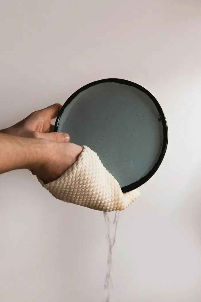 Mains nettoyant une assiette à l'aide d'un accessoire Design for Resilience.